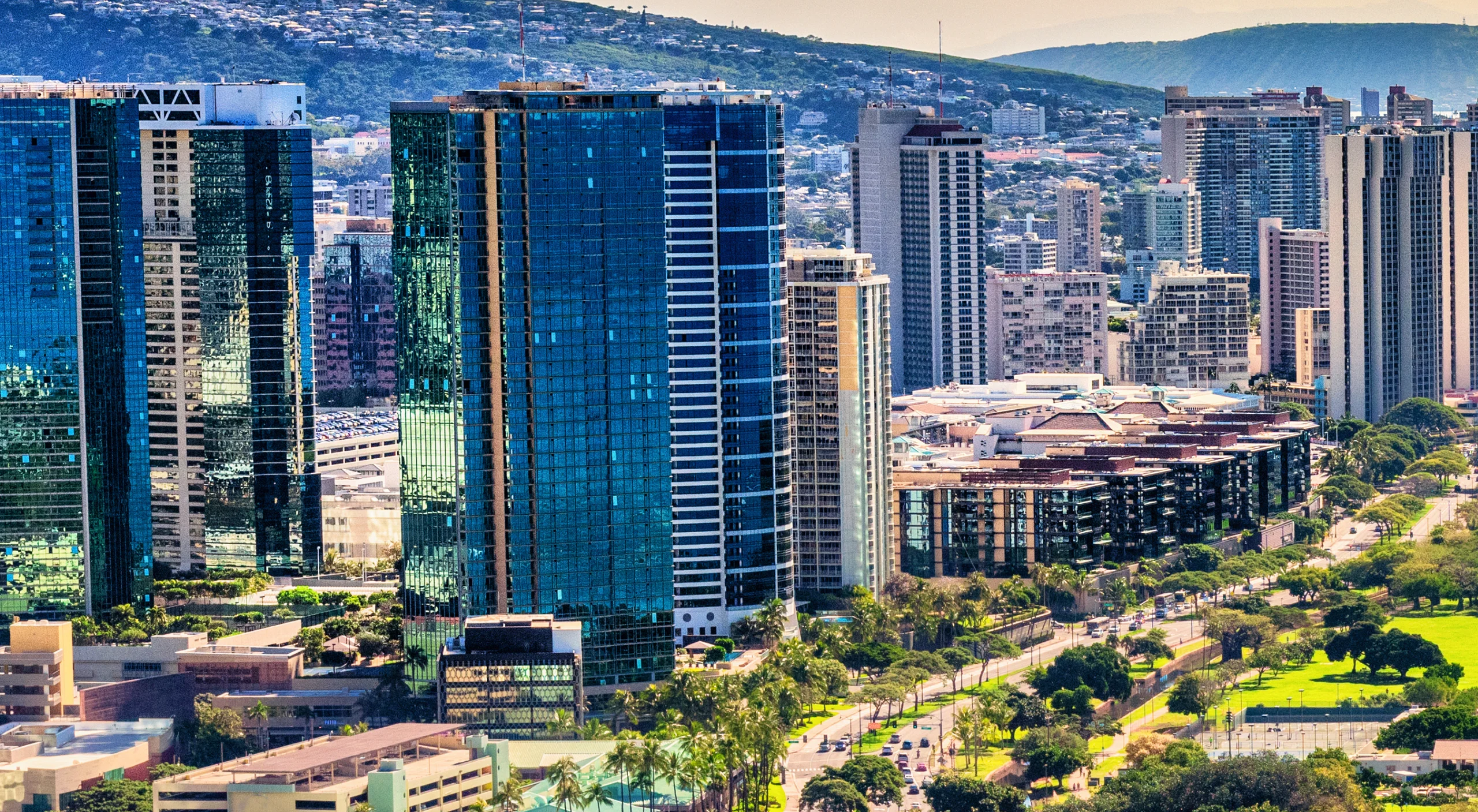 Aerial view of the Ward Village and Kakaʻako skyline rising above Ala Moana Beach Park in Honolulu